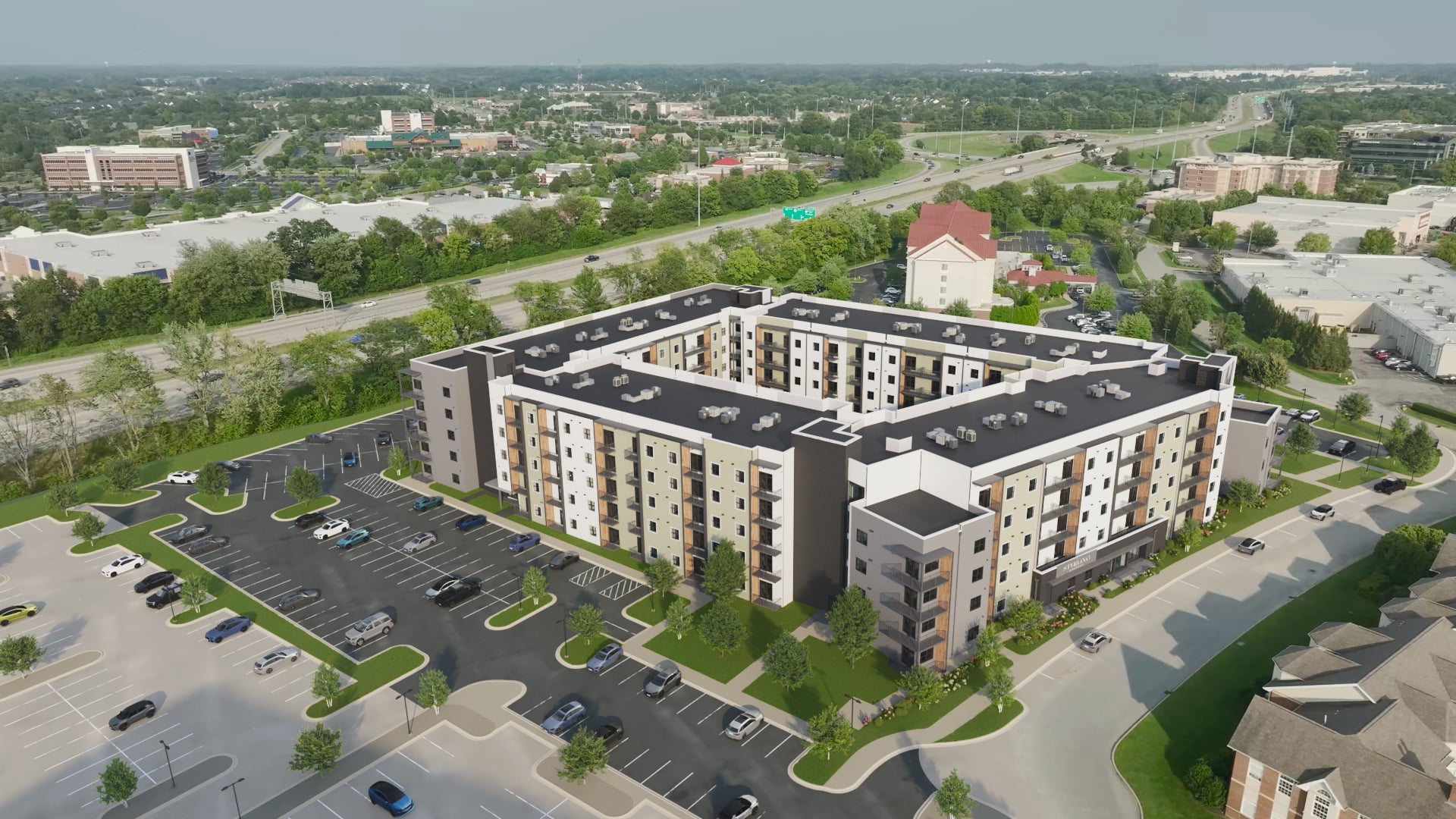 A large apartment complex with a parking lot in front.